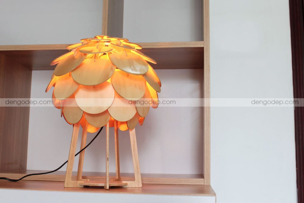 Đèn gỗ để bàn atiso chụp đối diện lúc thắp sáng