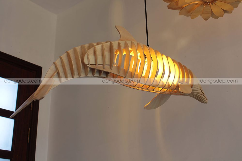 Đèn gỗ thả trần cá heo chụp lúc đã thắp sáng từ phía sau