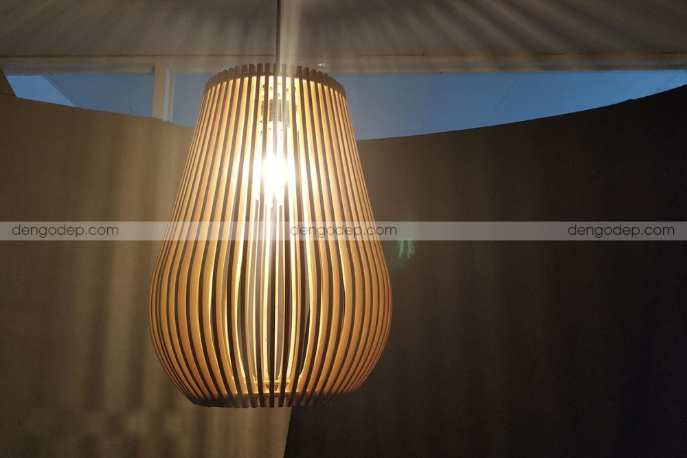 Đèn gỗ thả trần quả mận chụp gần khi được thắp sáng